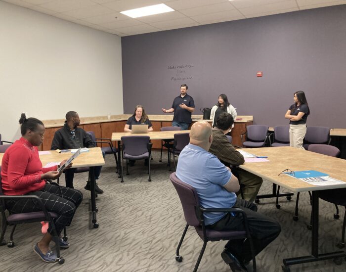 Sac Sewer representative speaking to a group of four job seekers.