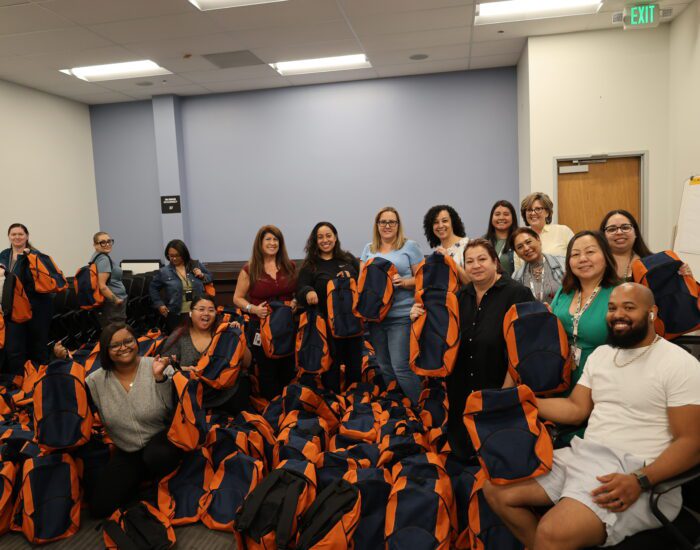Staff posing with 600 assembled backpacks