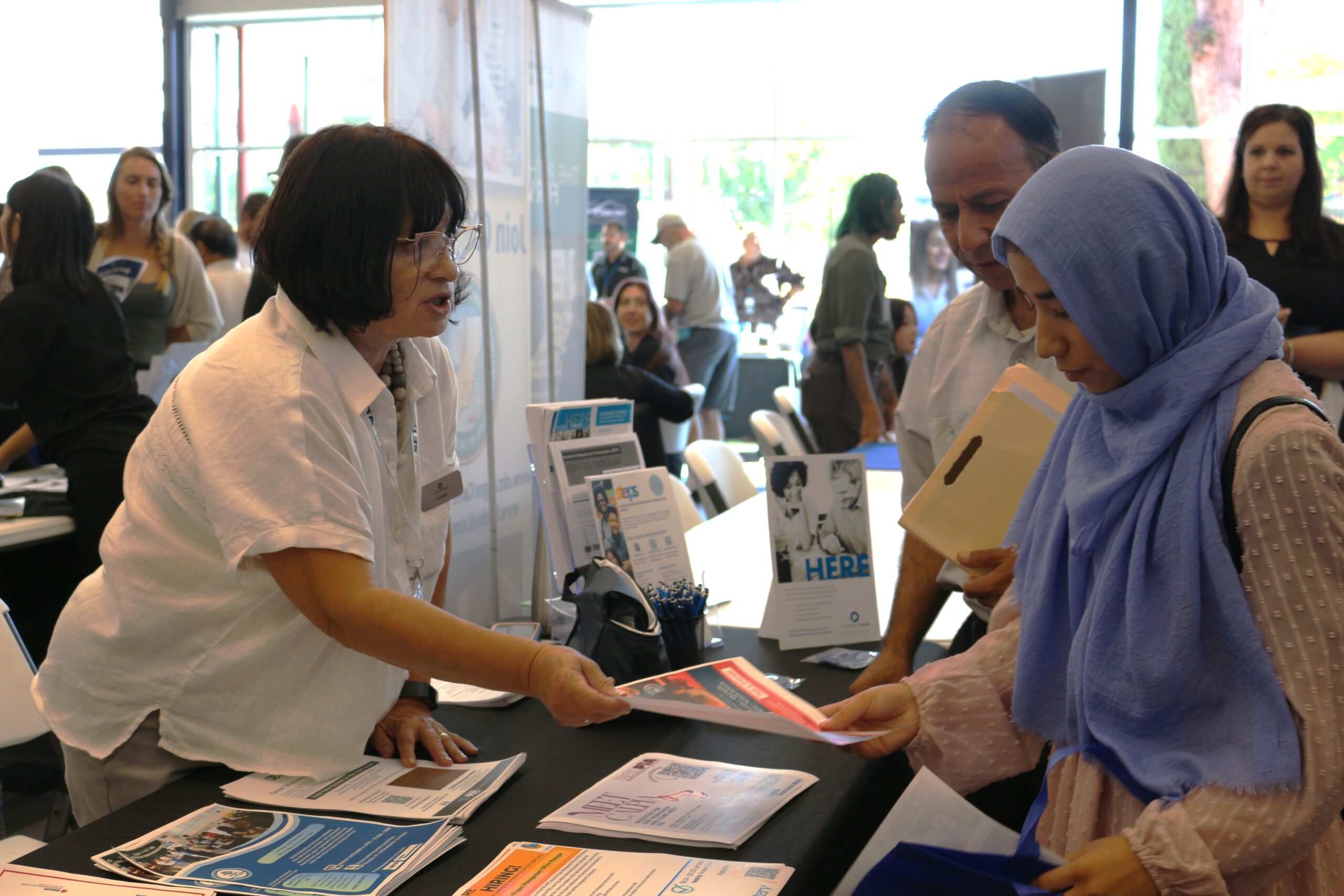 SETA staff member giving a paper handout to a community member